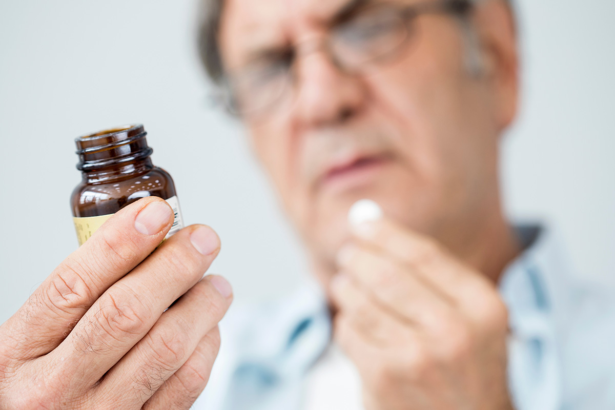 Old man taking a pill. (Adobe Stock │ #170326266 - sebra)