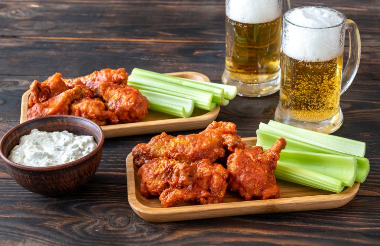 Buffalo wings with mugs of beer. (Adobe Stock │ #332735758 - alex9500)