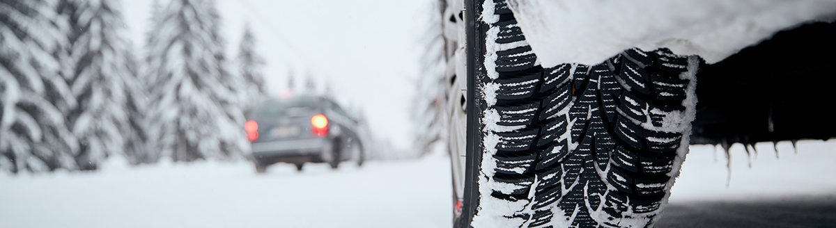 Close-up view of tire of car on snow covered and icy road. (Adobe Stock │ #404240289 - Chalabala)