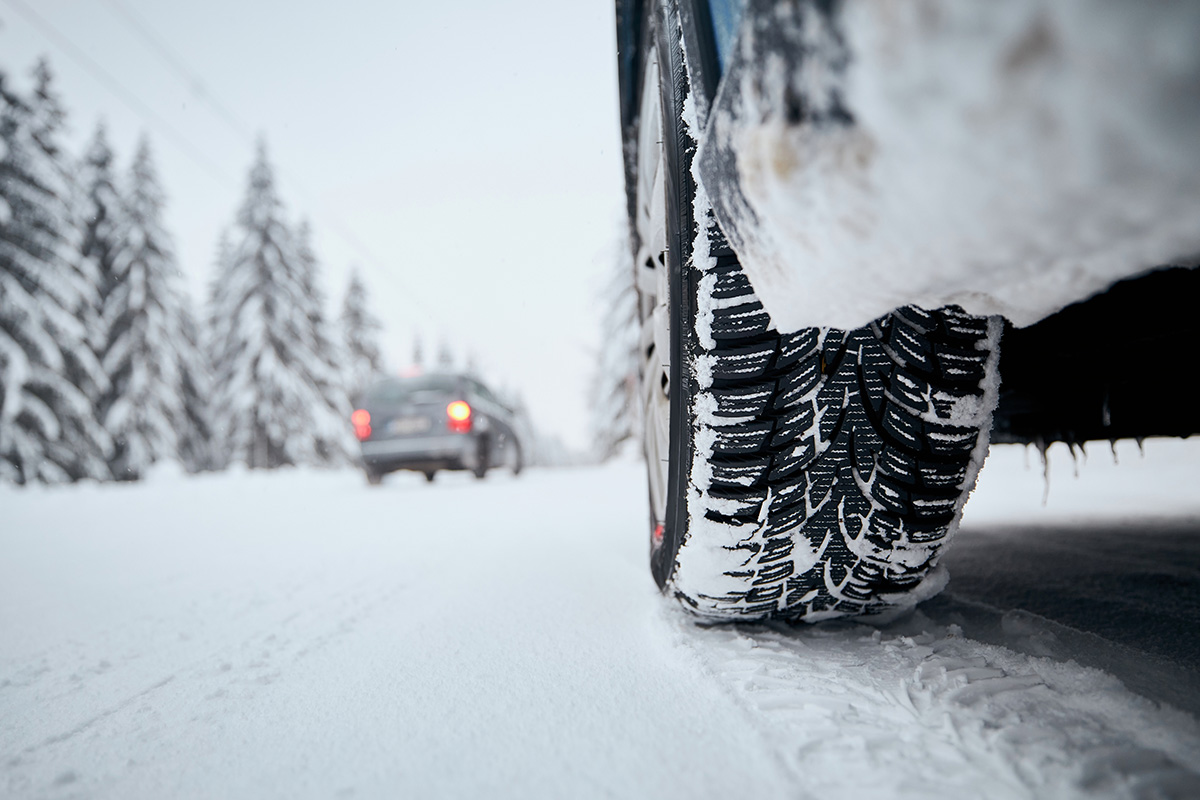Close-up view of tire of car on snow covered and icy road. (Adobe Stock │ #404240289 - Chalabala)