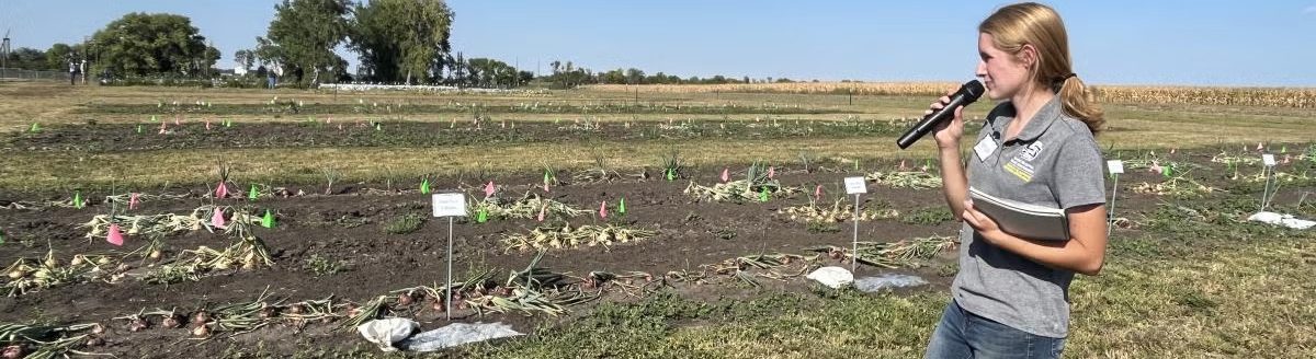 Hannah Voye, who graduated from SDSU in May 2025 with a master’s degree in plant science, talks about her research on soil tarping at an SDSU Extension event (SDSU Extension)