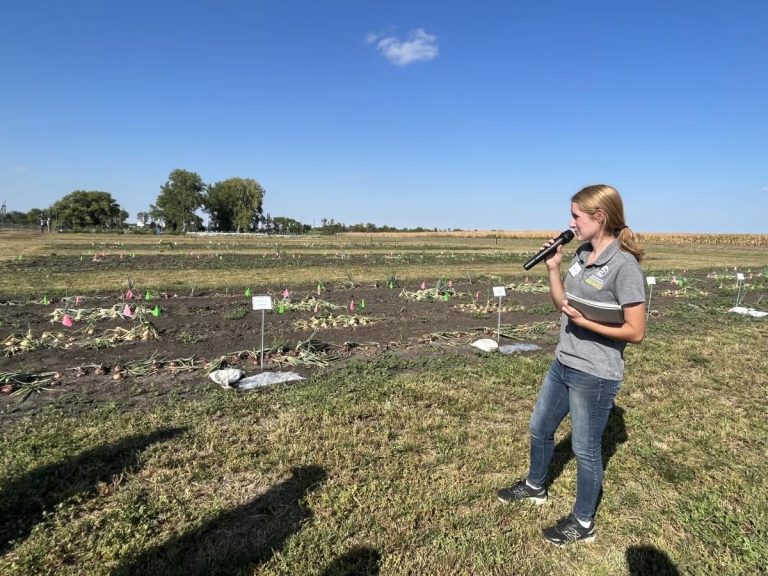 Hannah Voye, who graduated from SDSU in May 2025 with a master’s degree in plant science, talks about her research on soil tarping at an SDSU Extension event (SDSU Extension)