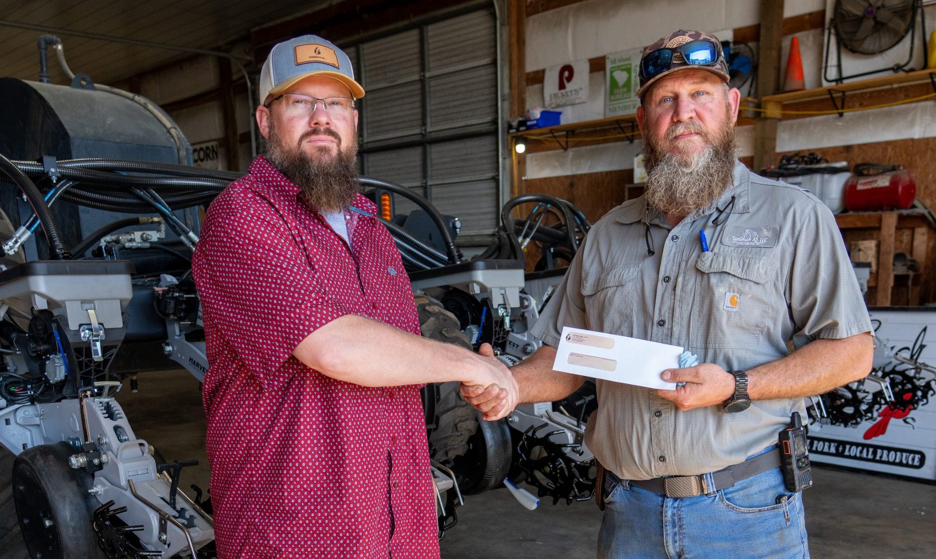 Creekside Carbon co-founder Josh McClain (left) presents a check to Zan Tomlinson. (Photo by Ben Clark.)