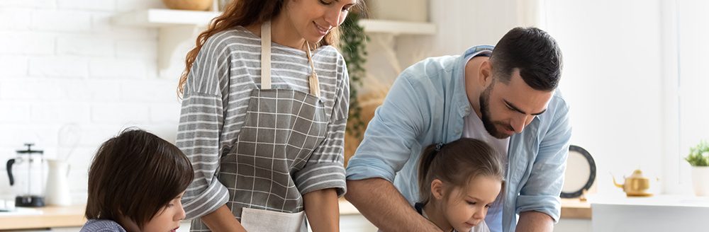 Young family with little kids cooking at home together. (Adobe Stock-#327423655 │ fizkes)