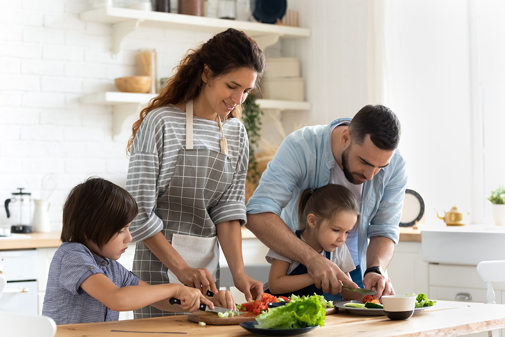Young family with little kids cooking at home together. (Adobe Stock-#327423655 │ fizkes)
