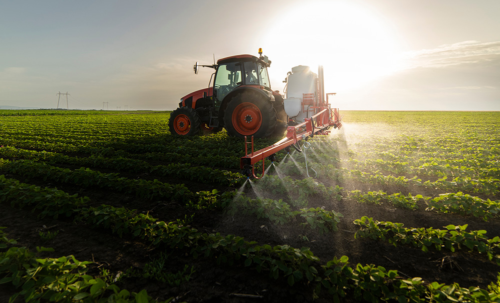 Tractor spraying soy field in sunset. (Adobe Stock-#355841291 │ Dusan Kostic)