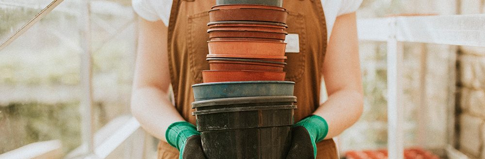 Gardener holding empty flower pots. (Adobe Stock-#396518765 │ Rawpixel.com)