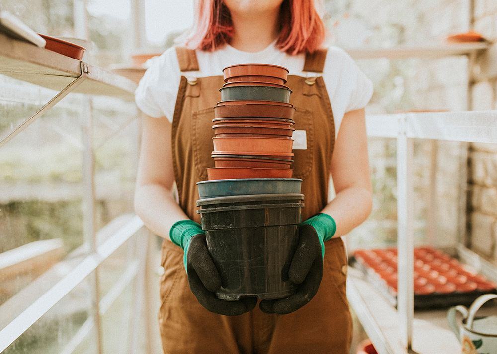 Gardener holding empty flower pots. (Adobe Stock-#396518765 │ Rawpixel.com)