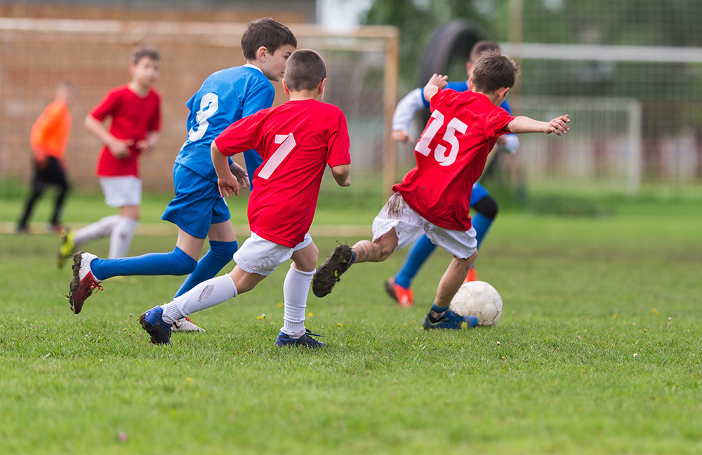 Boys kicking ball. (Adobe Stock-#110675056 │ Dusan Kostic)