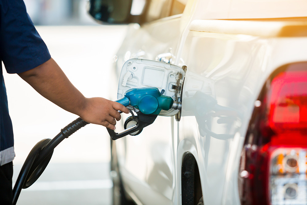 Refilling a white pickup truck with fuel at a gas station. (Adobe Stock-#247993817 │ Koonsiri)