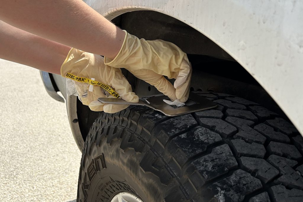 A researcher with the Texas A&M Department of Poultry Science collects a sample from the tire of a truck entering a poultry farm as part of a study examining how biosecurity practices can help reduce the spread of disease in poultry operations. (Lindsey Wythe/Texas A&M AgriLife)
