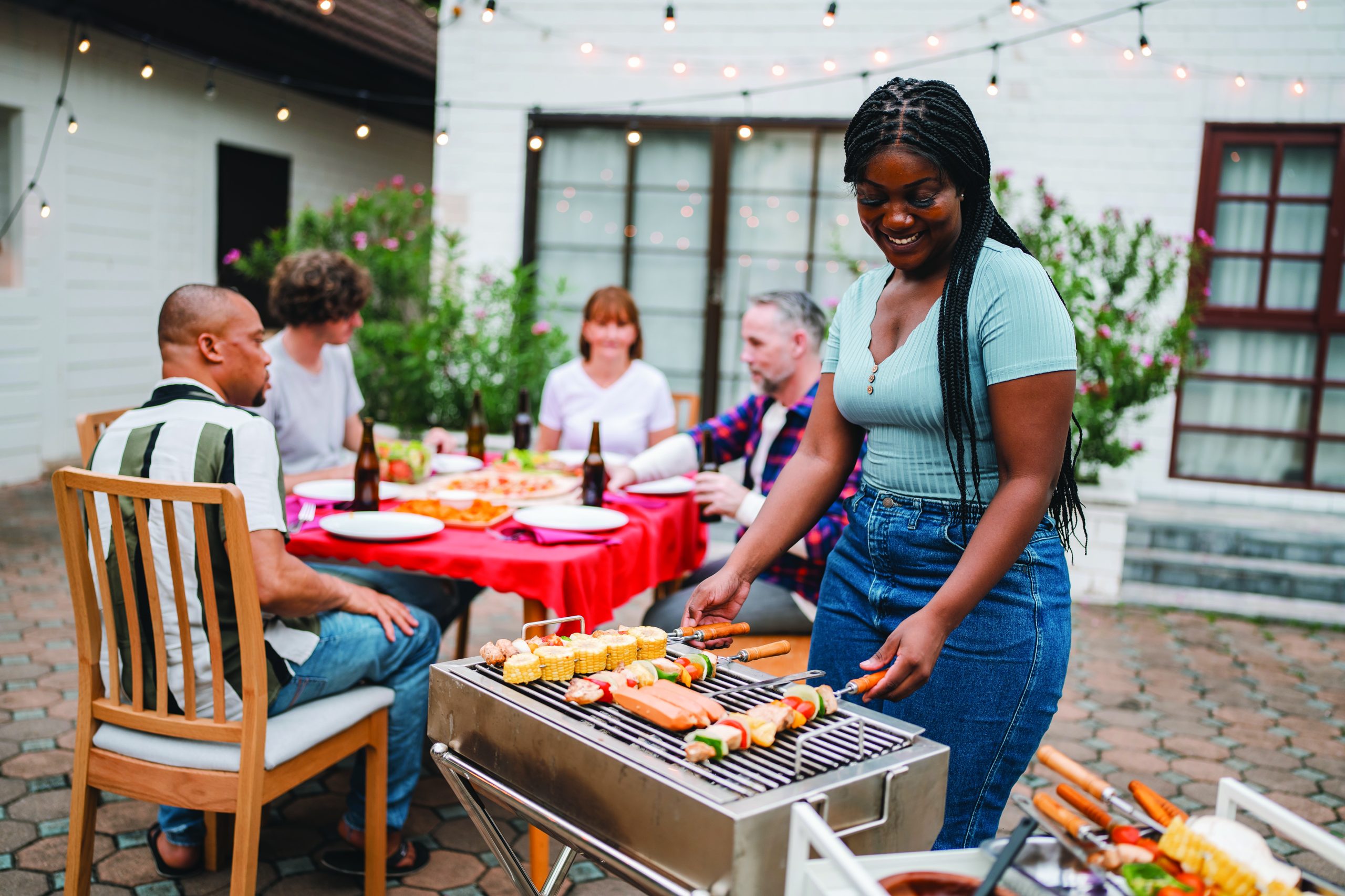 Cozy outdoor dining area set up for a rustic BBQ party. (Shutterstock-#2620008979 │ Chokniti-Studio)