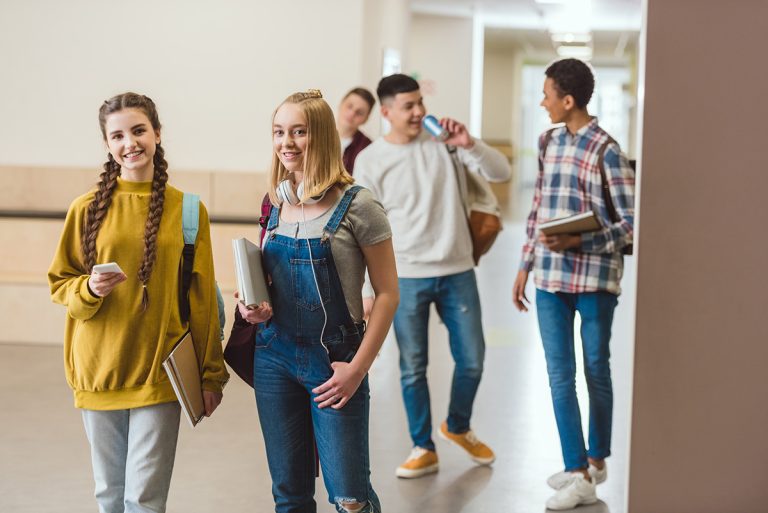 Group of happy high school classmates walking by school corridor together. (Adobe Stock-#200238277 │ LIGHTFIELD STUDIOS)