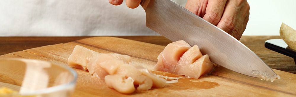 Cutting chicken fillet. (Adobe Stock-#300899613 │ ffolas)