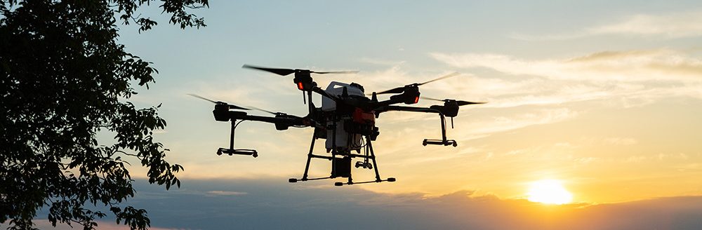 Farmer technicians remotely fly agricultural drones to fly to spray fertilizer in fields. (Adobe Stock-#571192845 │ Budjak Studio)