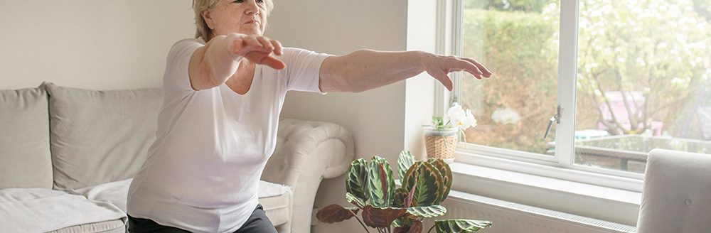 Active senior woman exercising at home. (Adobe Stock-#611308199 │ Elena)