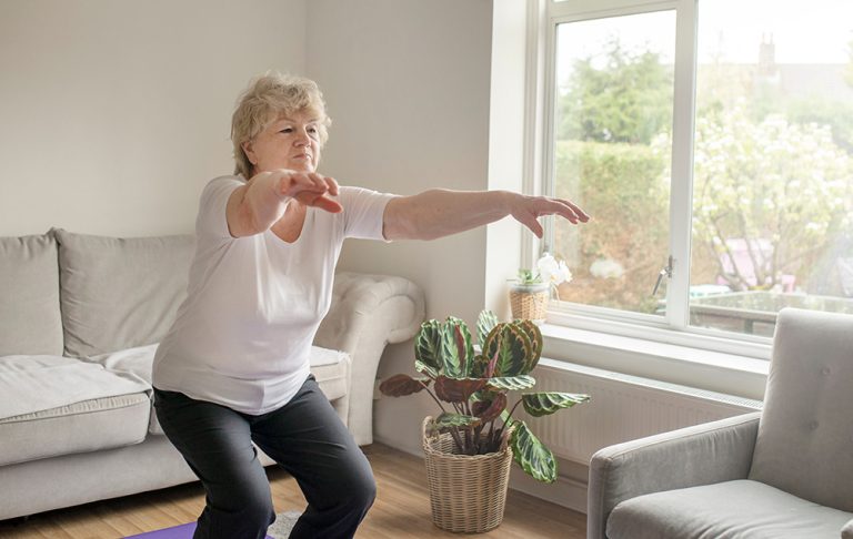 Active senior woman exercising at home. (Adobe Stock-#611308199 │ Elena)