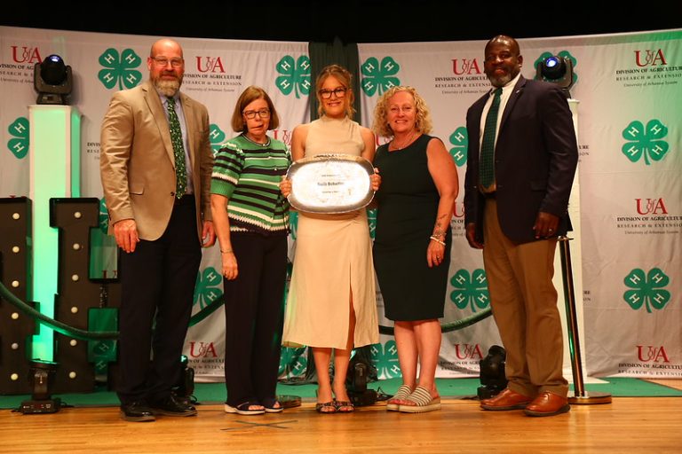 A CUT ABOVE — Sulli Schaffer, center, accepts the 2026 Arkansas 4-H Governor's Award at the State O-Rama Awards of Excellence ceremony in Fayetteville, Ark. (Division of Agriculture image.)