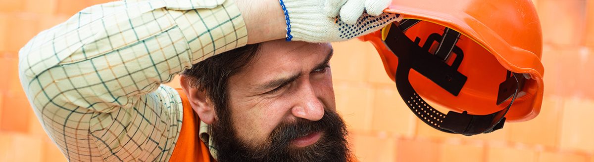 Male builder wipes sweat from brow. Physical work in hot weather. (Adobe Stock-#274558374 │ Tverdokhlib)