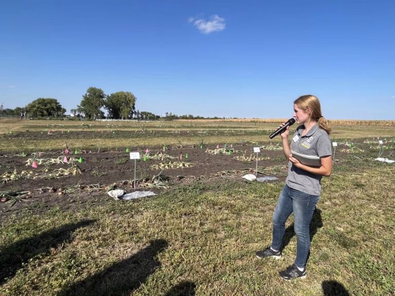 Hannah Voye, who graduated from SDSU in May 2025 with a master’s degree in plant science, talks about her research on soil tarping at an SDSU Extension event. (South Dakota State University Extension)
