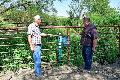 NRCS Resource Conservationist Pat Corey (right) talks to producer Ralph Dorale about his new livestock watering system that includes a solar-powered pumping plant that carries water to the top of a hill. (Jason Johnson - Iowa NRCS)