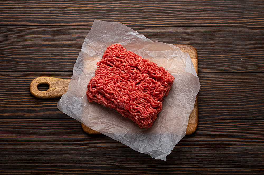 Ground beef on cutting board. (Adobe Stock-#427262684 │ somegirl)