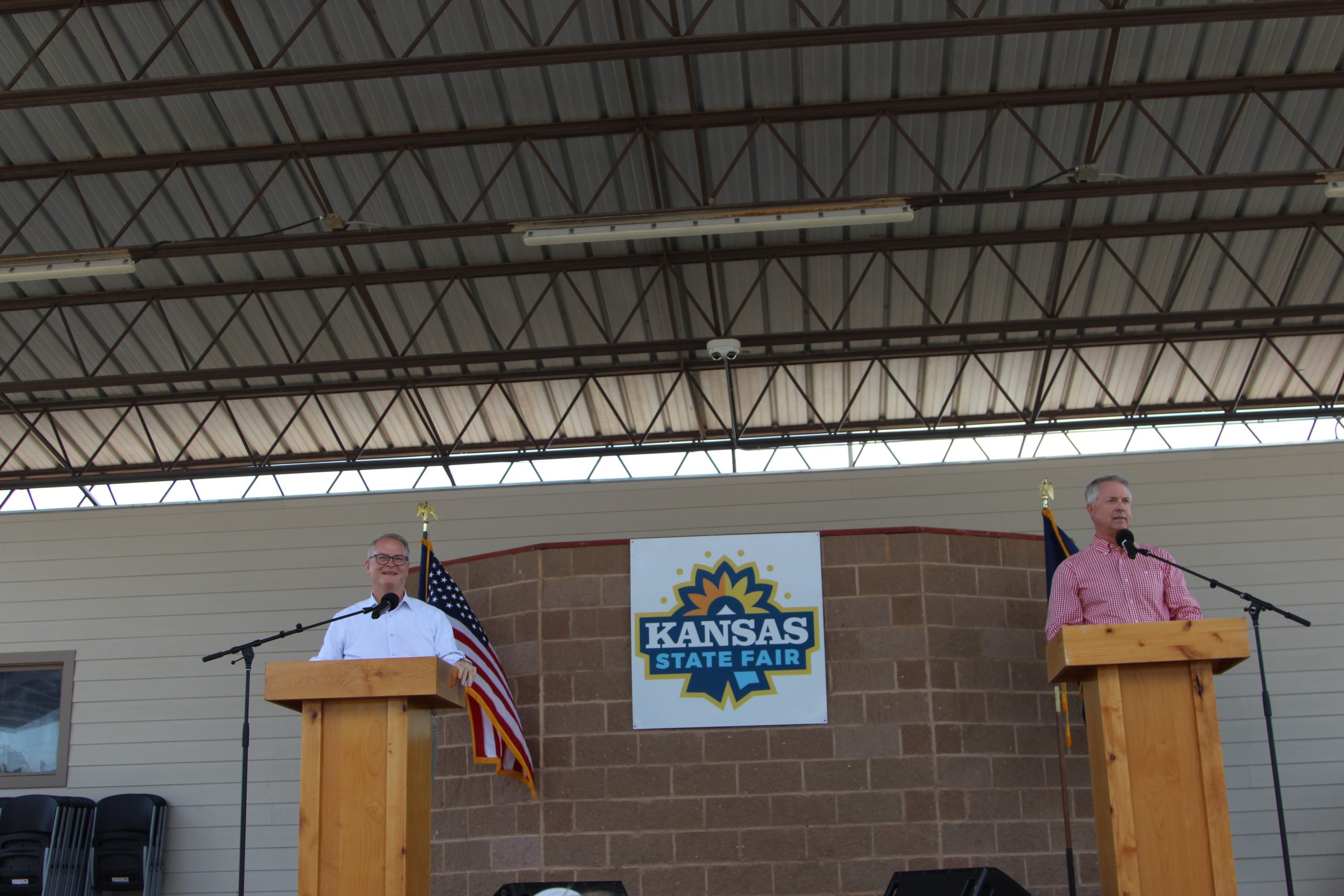 Adam Hamilton, left, and U.S. Sen. Roger Marshall acknowledge the crowd before the start of a debate at the Kansas State Fair. (Journal photo by Dave Bergmeier.)